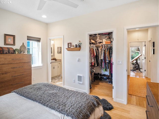 bedroom featuring a walk in closet, ensuite bath, ceiling fan, light hardwood / wood-style flooring, and a closet