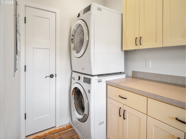 laundry area with cabinets, dark hardwood / wood-style floors, and stacked washer / dryer