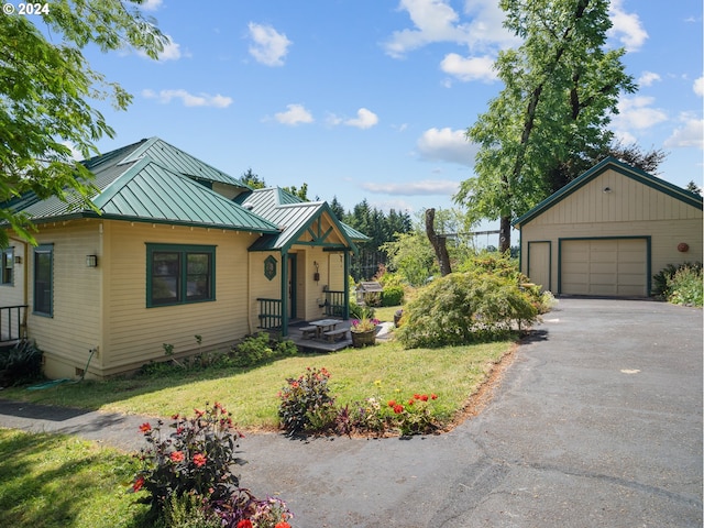 view of front facade featuring a front yard, a garage, and an outdoor structure