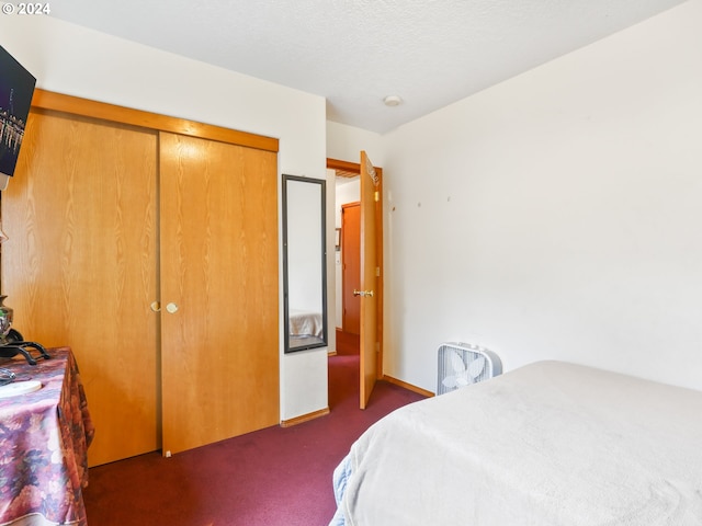 carpeted bedroom with a closet and a textured ceiling