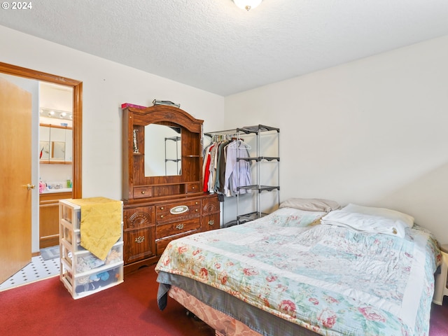 bedroom with a textured ceiling and dark colored carpet