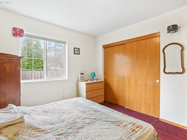 carpeted bedroom with a textured ceiling and a closet