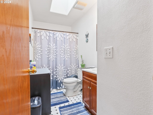 bathroom with a shower with curtain, a skylight, vanity, and toilet