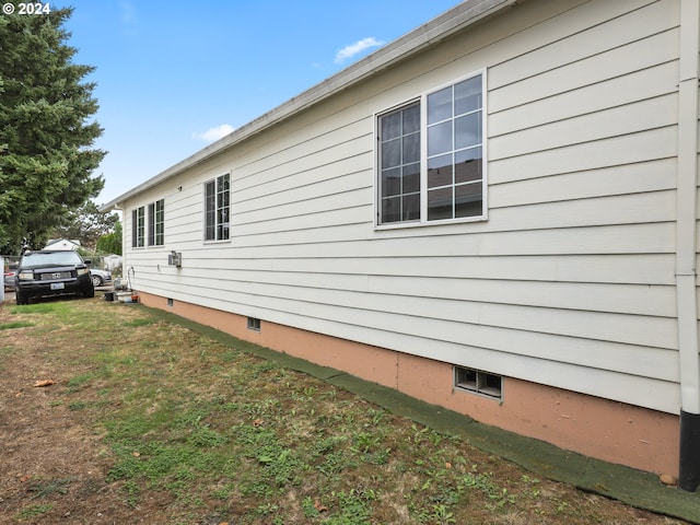 view of side of home with a yard