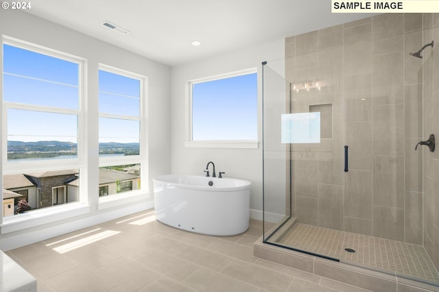 bathroom featuring tile patterned floors, shower with separate bathtub, and a water view