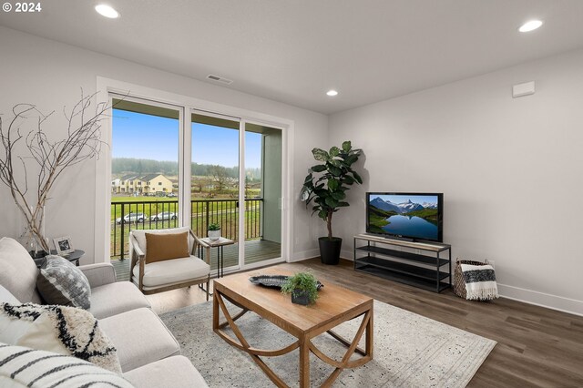 living room featuring dark wood-type flooring, recessed lighting, visible vents, and baseboards