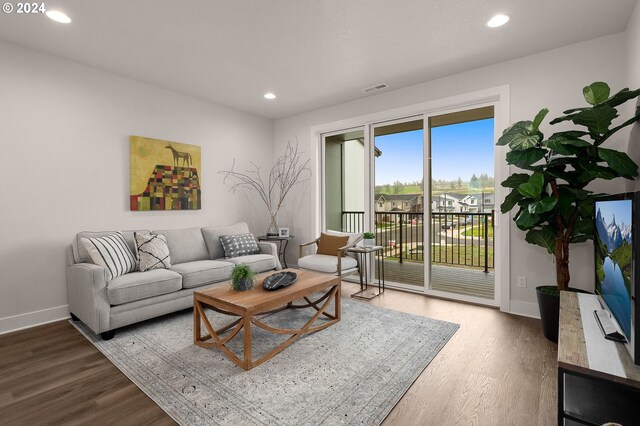 living room with baseboards, wood finished floors, visible vents, and recessed lighting