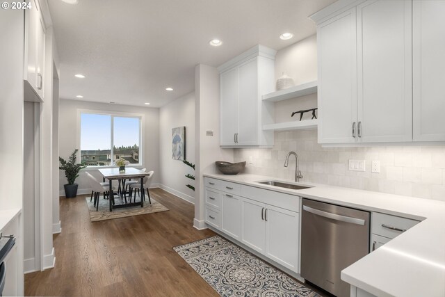 kitchen with white cabinets, sink, stainless steel dishwasher, dark hardwood / wood-style floors, and tasteful backsplash