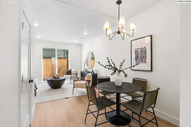 dining area with hardwood / wood-style floors and a chandelier