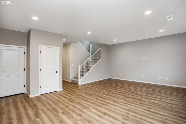 basement with stairs, wood finished floors, visible vents, and recessed lighting