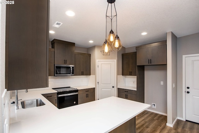 kitchen with black / electric stove, stainless steel microwave, a sink, and dark brown cabinetry