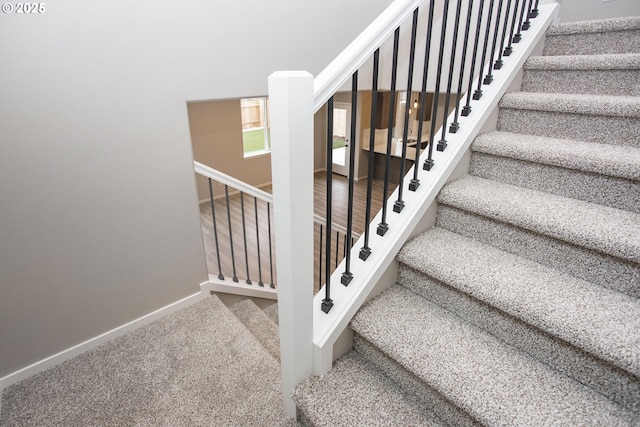 staircase with carpet floors and baseboards