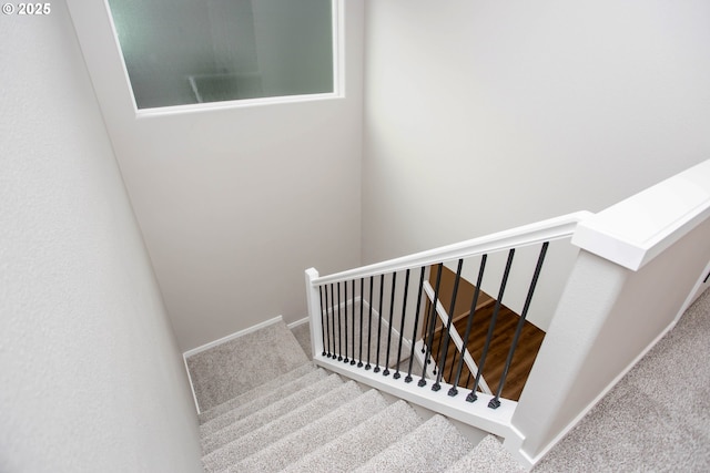 staircase featuring carpet floors and baseboards