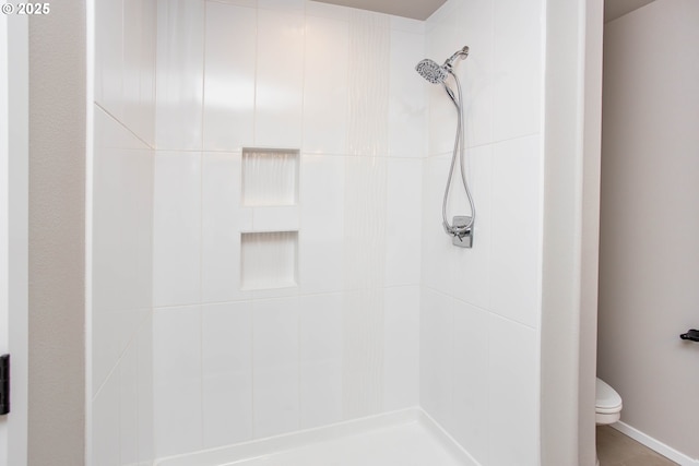 bathroom with tiled shower and toilet