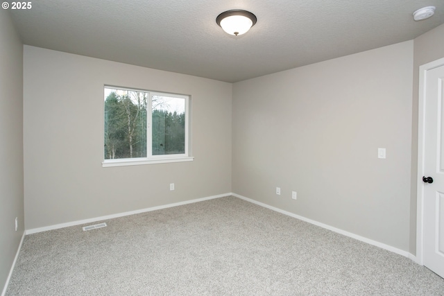 carpeted empty room with a textured ceiling, visible vents, and baseboards