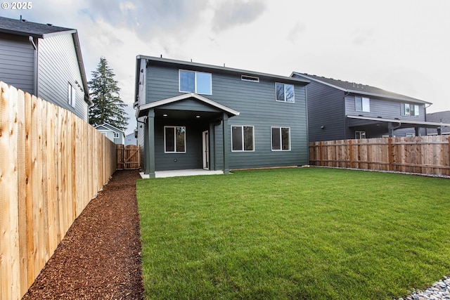 back of property featuring a patio area, a yard, and a fenced backyard