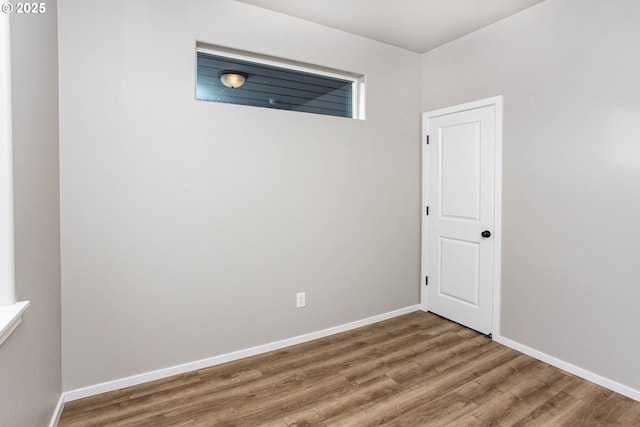 spare room with wood finished floors and baseboards