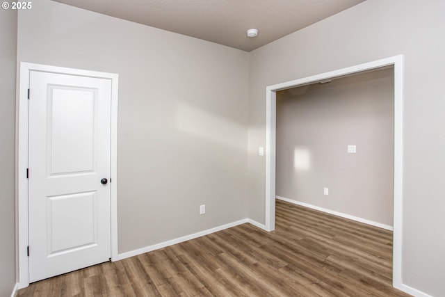 empty room featuring baseboards and wood finished floors