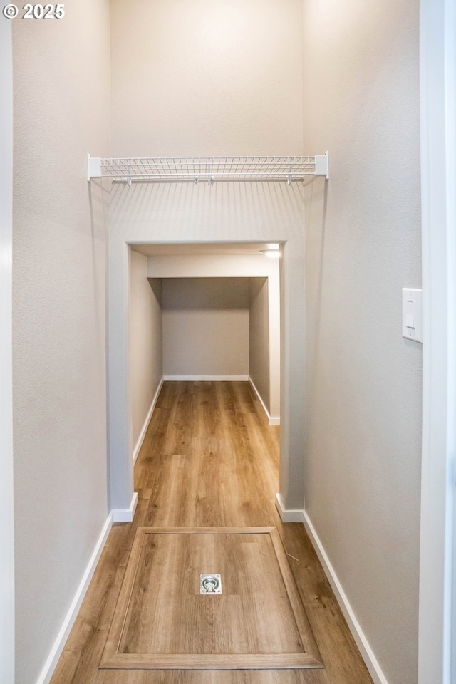 hallway featuring baseboards and wood finished floors