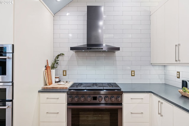 kitchen with stainless steel appliances, white cabinetry, tasteful backsplash, and wall chimney exhaust hood