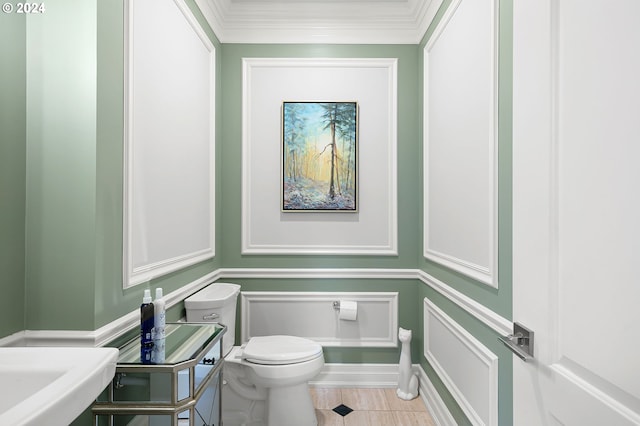 bathroom featuring tile patterned floors, crown molding, sink, and toilet