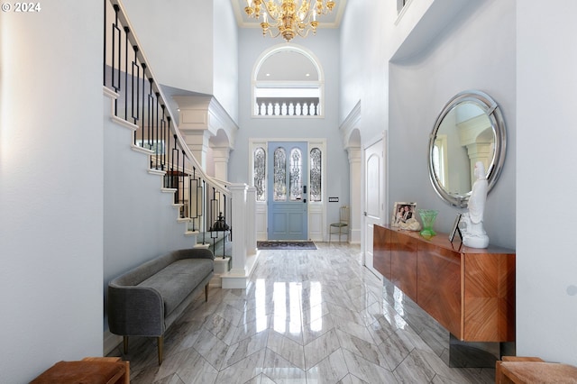 foyer entrance featuring crown molding, a chandelier, and a high ceiling