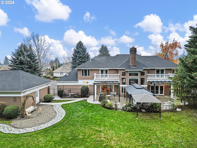 rear view of house featuring a gazebo, a yard, a balcony, and a patio area