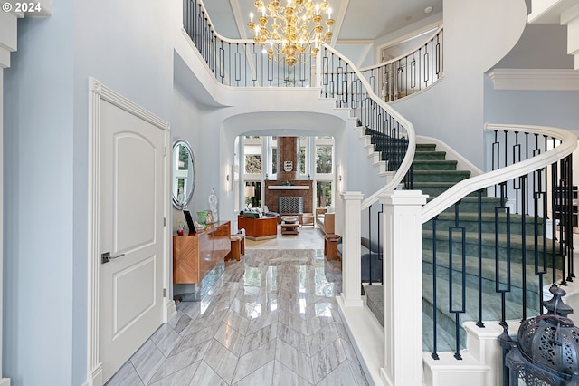 entrance foyer featuring a towering ceiling, crown molding, and a notable chandelier