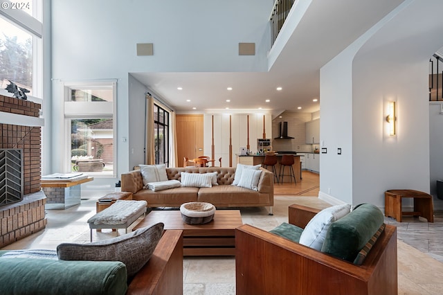 living room featuring a towering ceiling and a brick fireplace