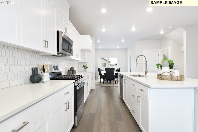 kitchen with appliances with stainless steel finishes, sink, dark hardwood / wood-style floors, and white cabinets