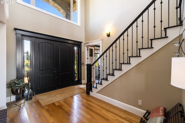 foyer entrance featuring hardwood / wood-style flooring and a towering ceiling