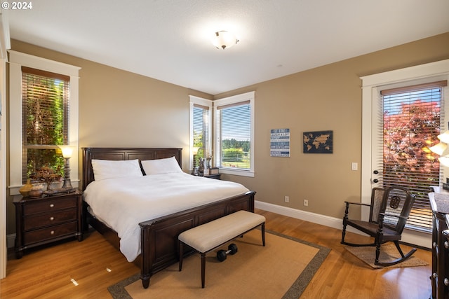 bedroom with multiple windows and hardwood / wood-style flooring