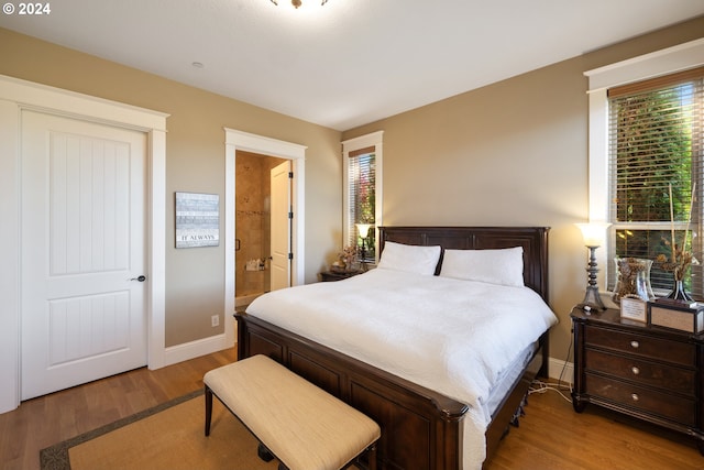 bedroom with wood-type flooring and connected bathroom