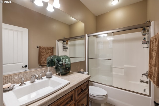 full bathroom featuring shower / bath combination with glass door, vanity, tasteful backsplash, and toilet