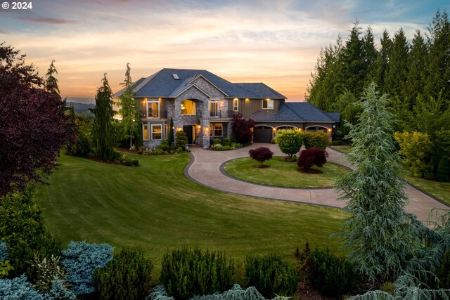 view of front of home featuring a lawn, a garage, and a balcony