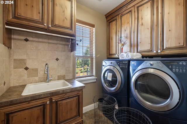 clothes washing area featuring washer and dryer, cabinets, and sink