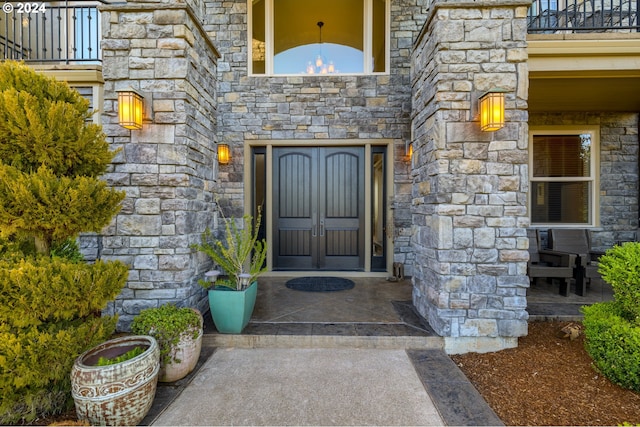 view of exterior entry featuring a balcony