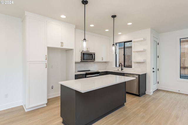 kitchen featuring light hardwood / wood-style floors, stainless steel appliances, a kitchen island, and white cabinets