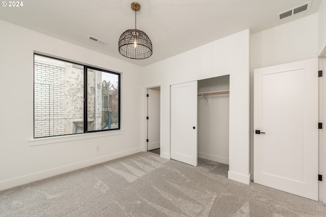 unfurnished bedroom featuring light colored carpet and a closet