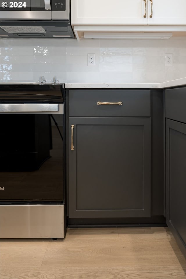 details featuring light hardwood / wood-style flooring and stainless steel stove