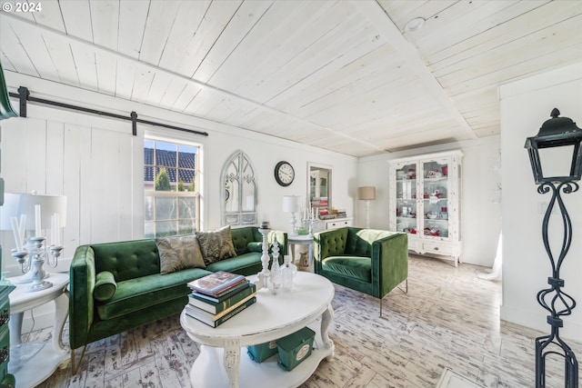 living room featuring a barn door, light hardwood / wood-style floors, and wooden ceiling