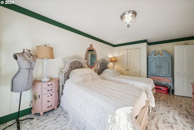 bedroom featuring ornamental molding, light hardwood / wood-style flooring, and a closet