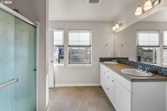 bathroom featuring tile patterned floors, a wealth of natural light, vanity, and an enclosed shower