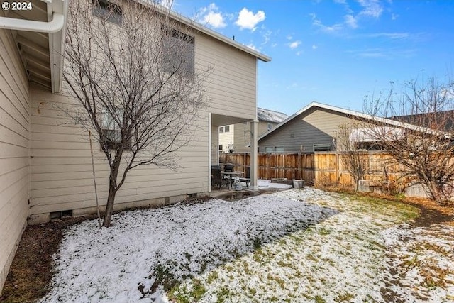 view of snow covered back of property