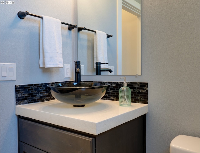 bathroom with vanity, toilet, and backsplash