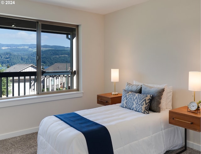 carpeted bedroom featuring a mountain view and multiple windows