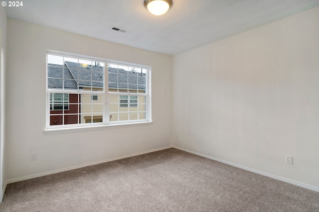 carpeted empty room with visible vents and baseboards
