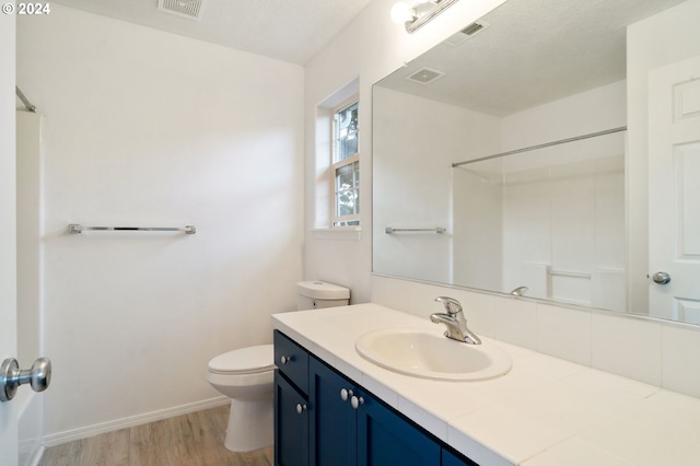 full bathroom with visible vents, toilet, wood finished floors, a shower, and baseboards