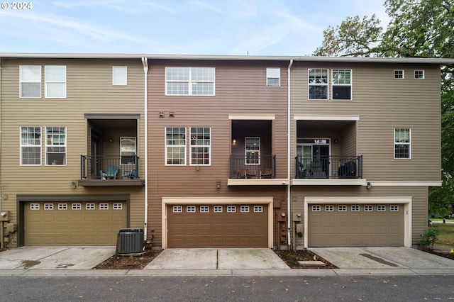 townhome / multi-family property with cooling unit and a garage