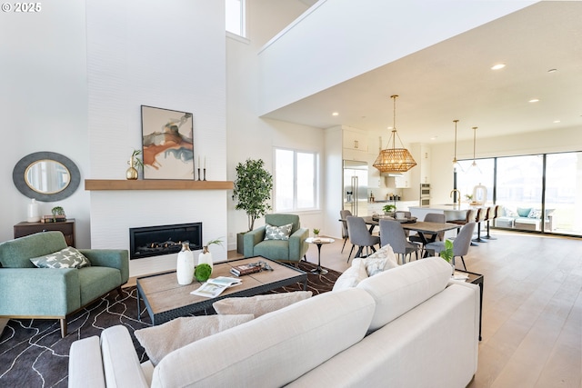 living room with a high ceiling, a large fireplace, and hardwood / wood-style floors